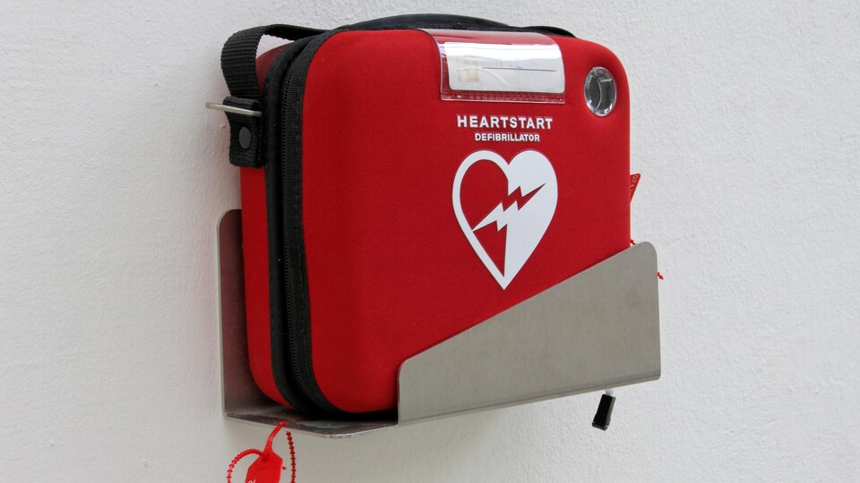 Un défibrillateur cardiaque rouge fixé au mur.