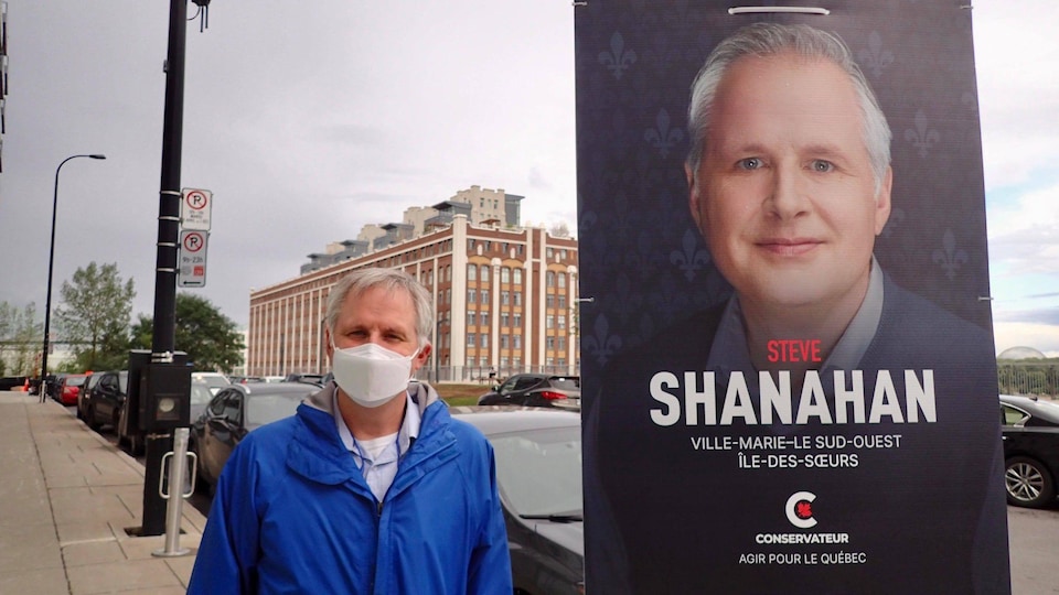 Steve Shanahan pose à côté de sa pancarte électorale.