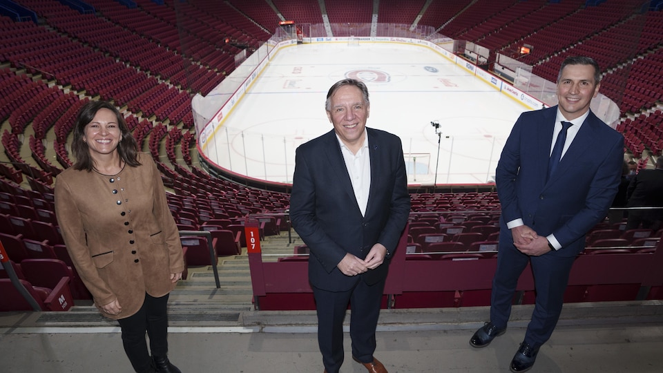 The three stood smiling at the Bell Center stand.
