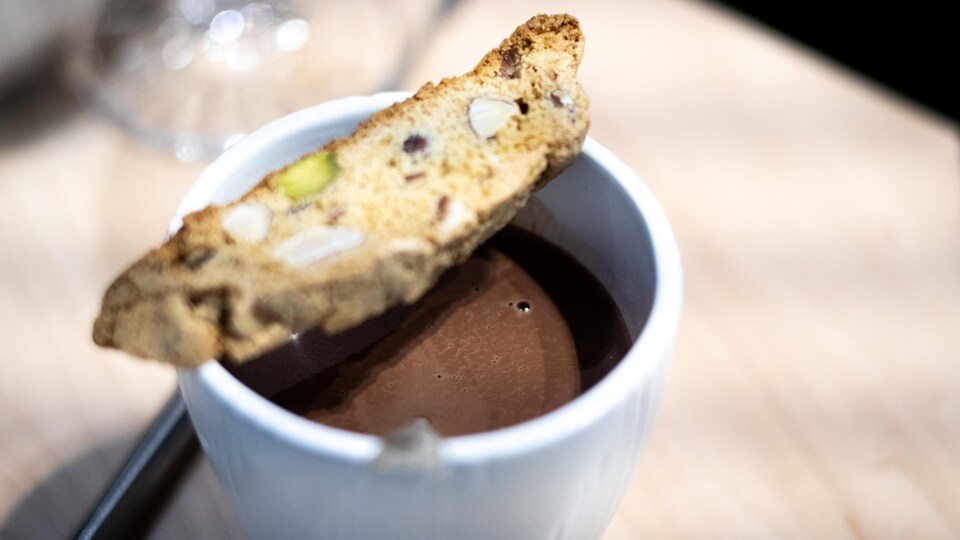 Photo d'une tasse de chocolat chaud avec un biscotti sur le dessus.