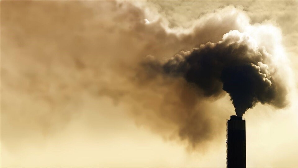 Une tour rejette une grande quantité de fumée dans l'atmosphère.