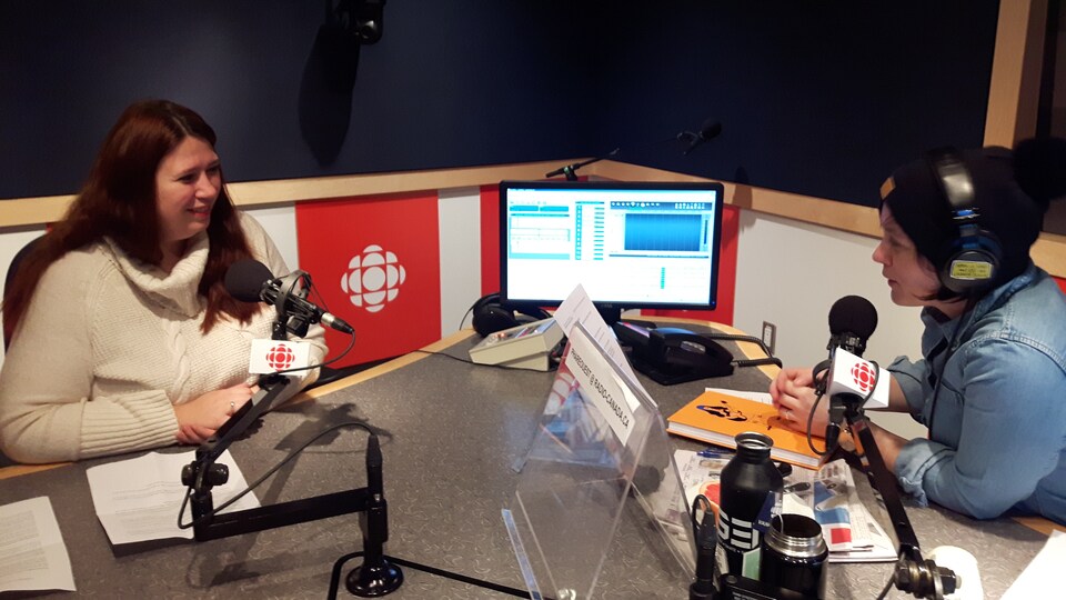 Deux femmes sont assises, devant un micro, dans un studio de radio.