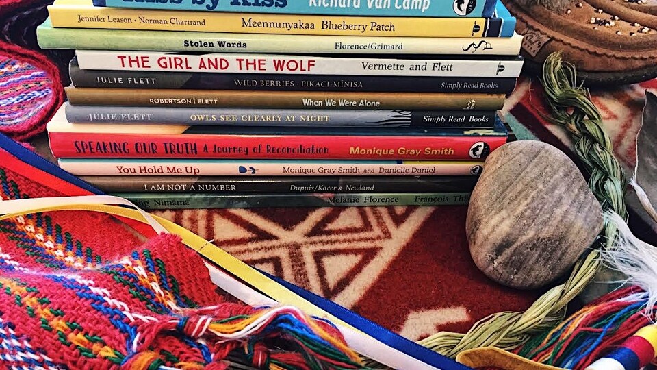 Une pile de livres à côté d'une tige de sauge.