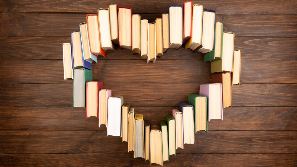 Des livres sont posés sur un plancher et forment un coeur.