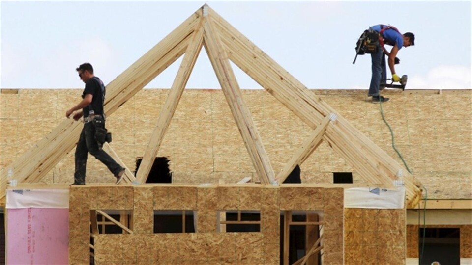 Des travailleurs de la construction construisent une maison à Calgary en 2015.