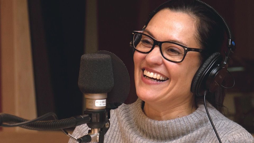 Brigitte Poupart riant dans un studio de radio.
