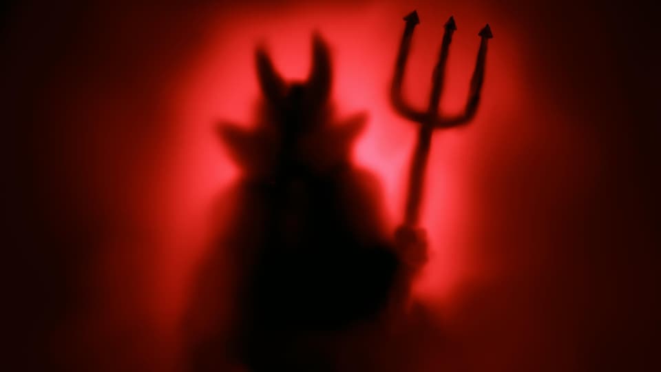 Dans la brume, une silhouette de Satan.