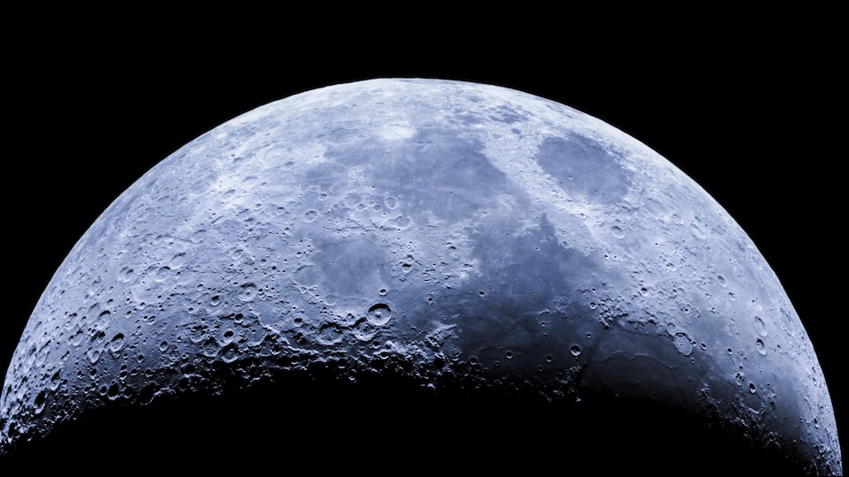Gros plan d'un croissant de lune et des détails des cratères à sa surface vue de l'hémisphère sud.