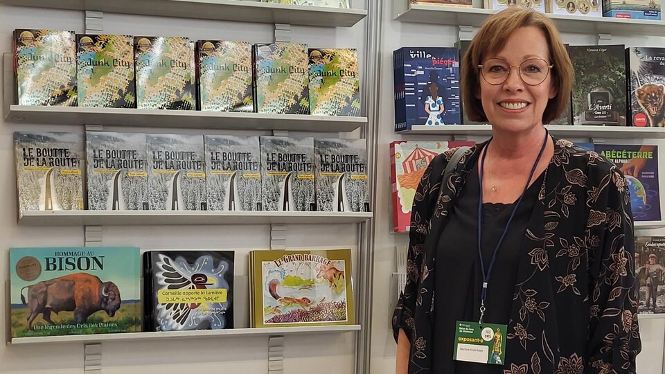 Martine Noël-Maw devant une étagère de livres.
