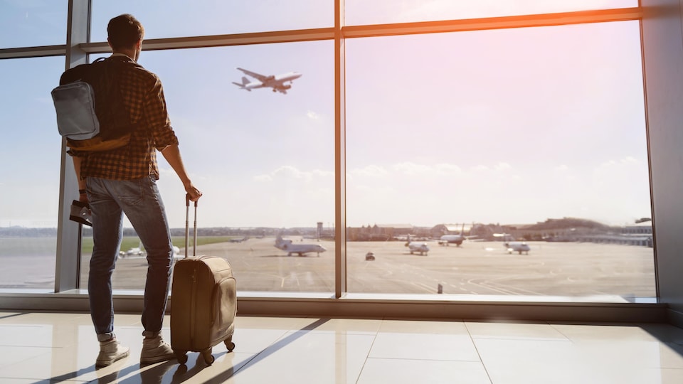 Un touriste observe un avion à l'aéroport.