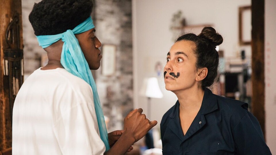 Vlad Alexis peint des moustaches sur le visage d'Aviva Armour Ostroff