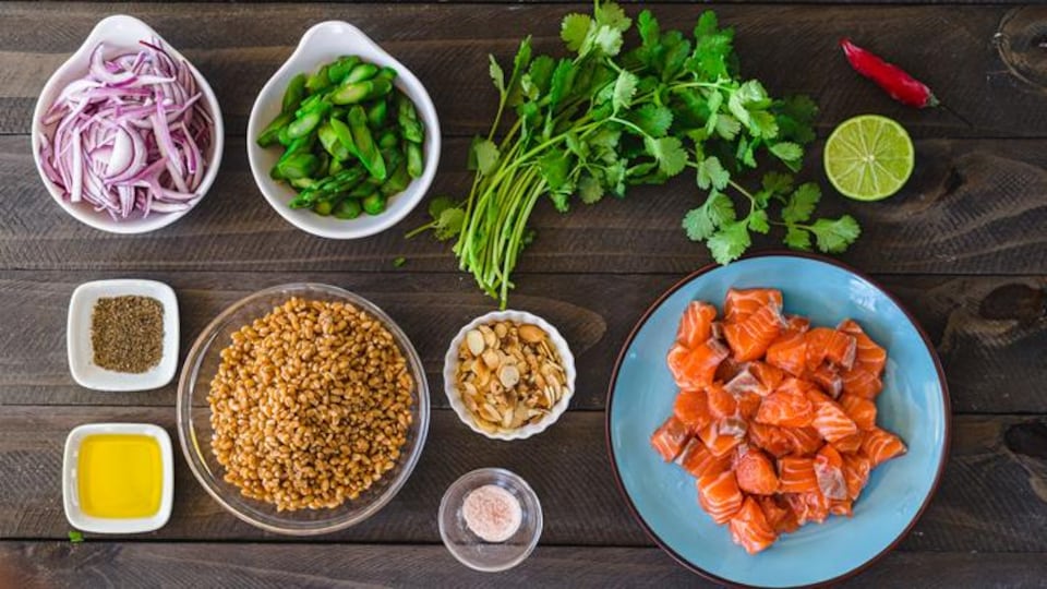 Mise en place d'une salade d'orge et des morceaux de saumon.