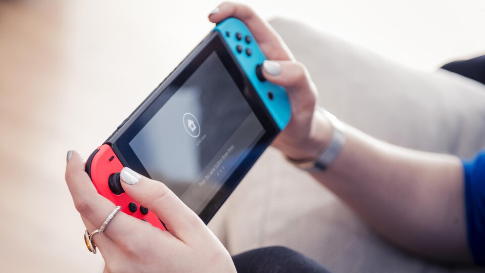 Une personne joue avec une Nintendo Switch.