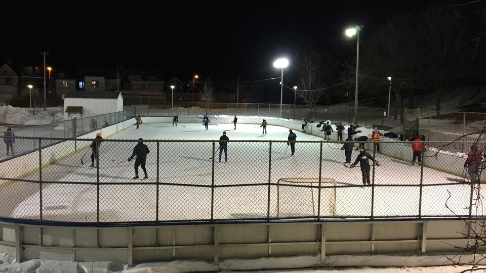Des personnes jouent au hockey sur une patinoire.