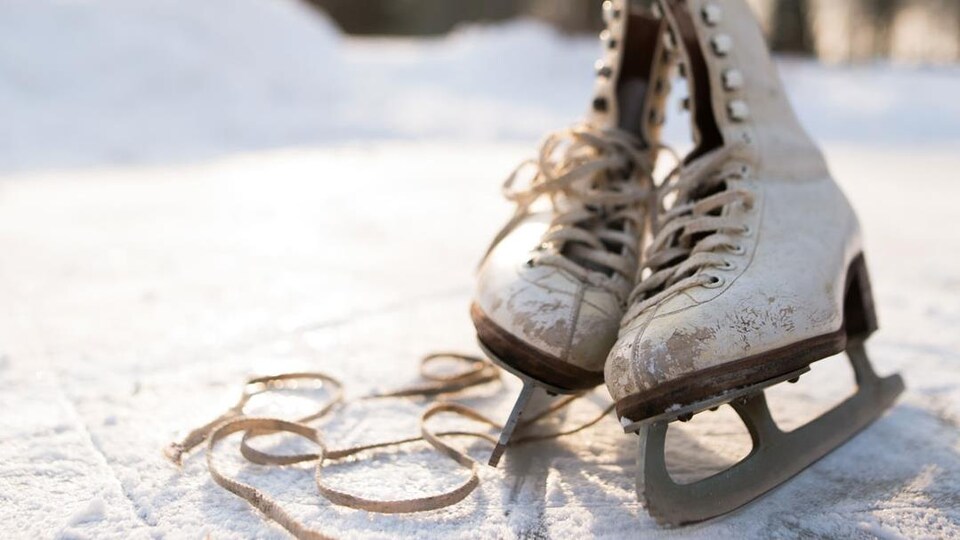 Photo d'une vielle paire de patins à glace sur une patinoire extérieure.