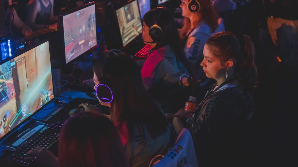 Des femmes jouent à un jeu vidéo lors d'un événement de sport électronique.