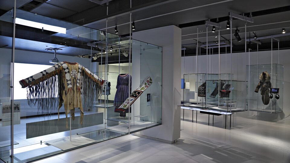 Une salle d'exposition dans laquelle on peut voir des objets sous verre: des tenues traditionnelles notamment.