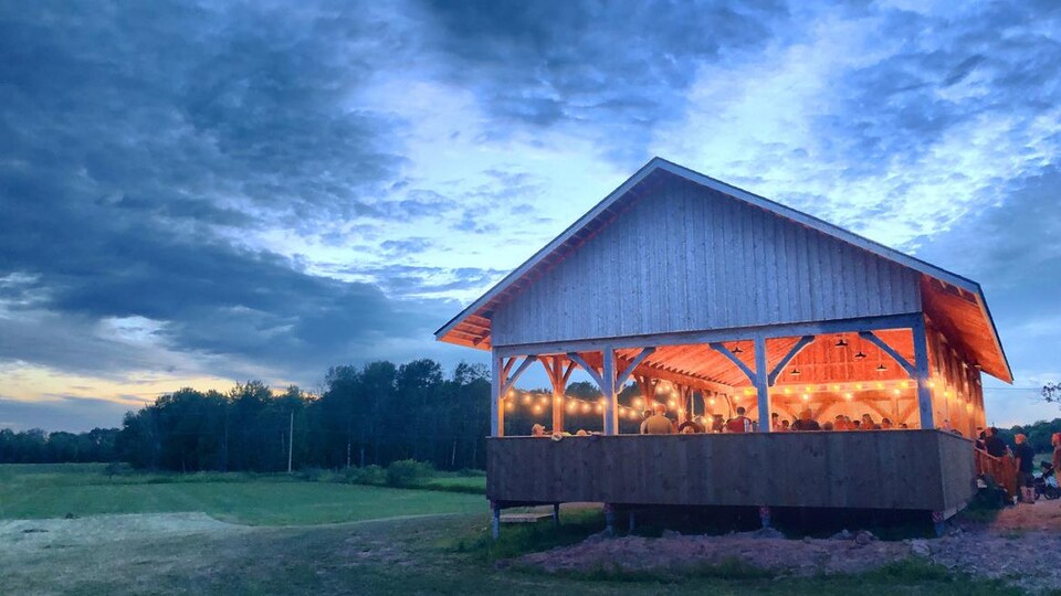 Un pavillon extérieur au milieu d'un champ où les gens se rencontrent pour une soirée dansante traditionnelle