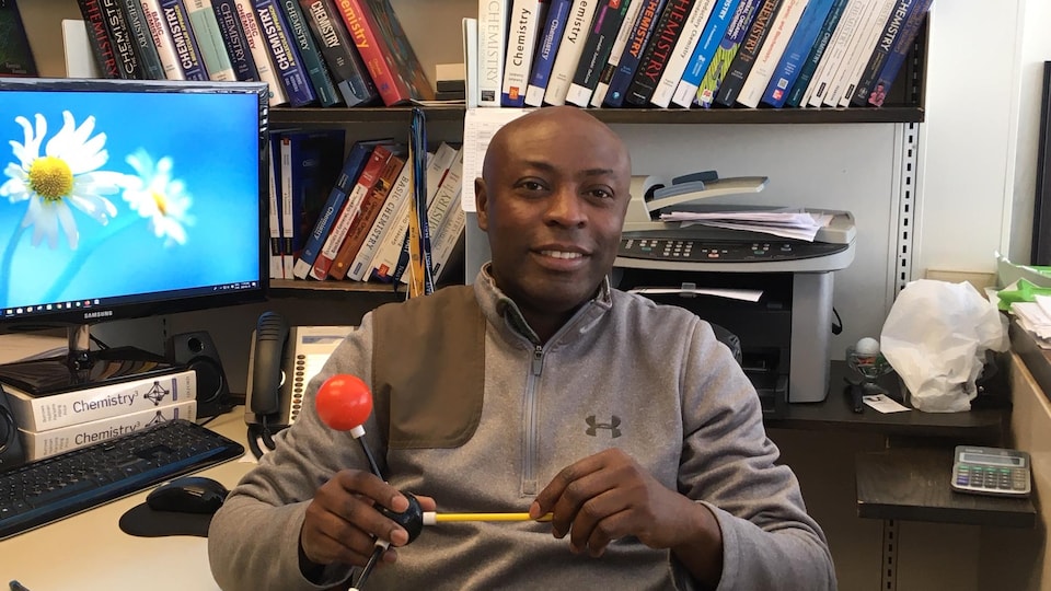 Gabriel Oba assis à son bureau.