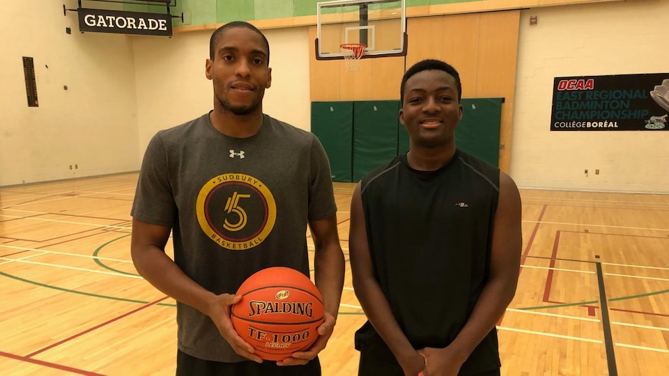 Georges Serresse et Cheik Sangaré dans un gymnase. Georges tient un basketball.