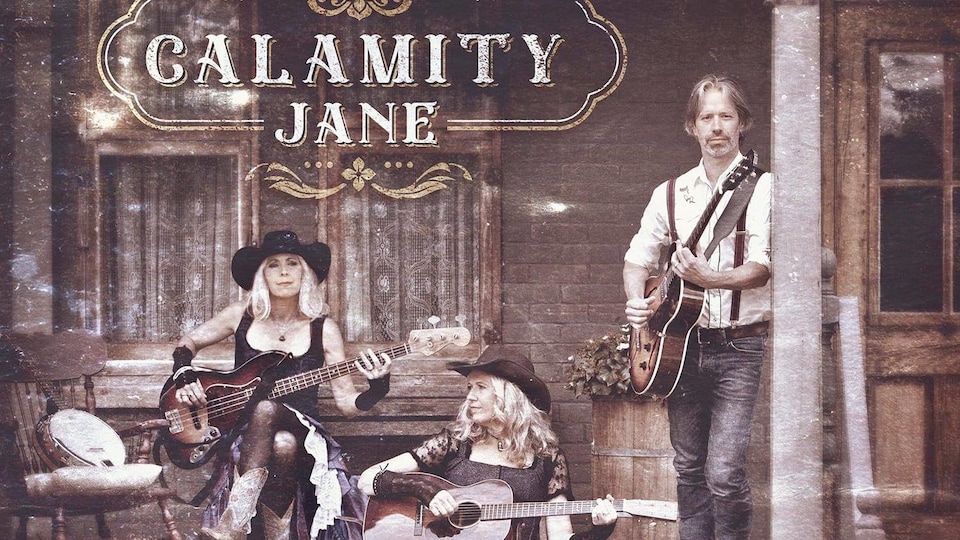 La pochette de l’album La légende de Calamity Jane : deux femmes sont assises et un homme est debout sur le perron d’une vieille maison; tous tiennent une guitare ou une basse
