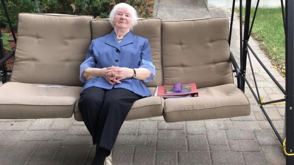 Marthe Dallaire âgée de 91 ans, est assise confortablement dans une balançoire à l'extérieur du Foyer des pionniers de Hearst, où elle continue de faire du bénévolat à chaque semaine.