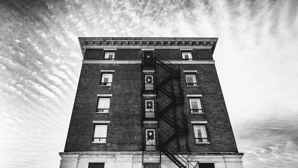 Un édifice de briques avec un escalier d'urgence au centre de l'édifice.