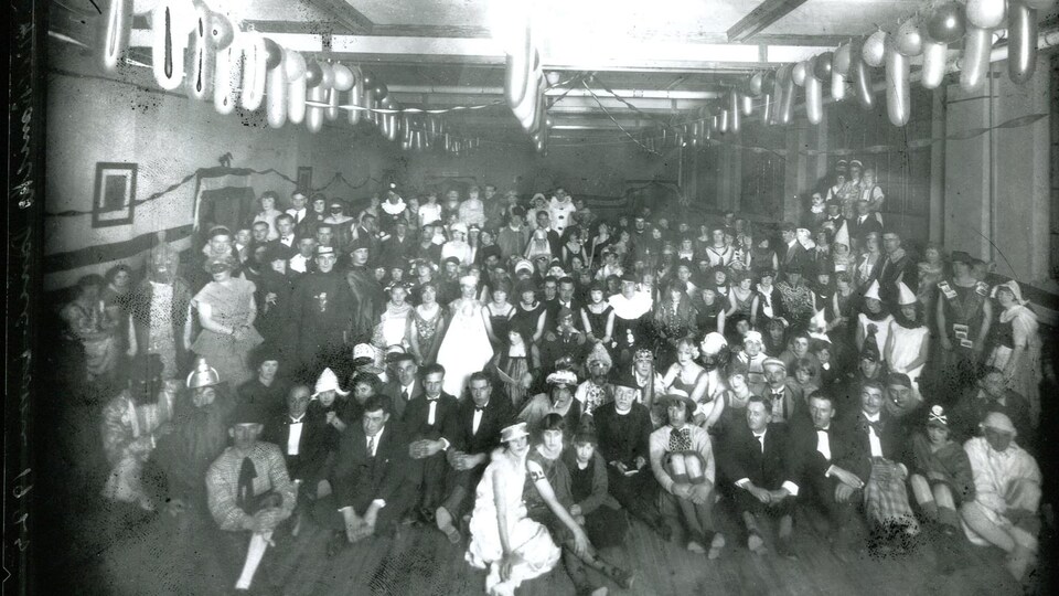 Une photo de groupe prise lors d’un bal masqué au tournant du 20e siècle.
