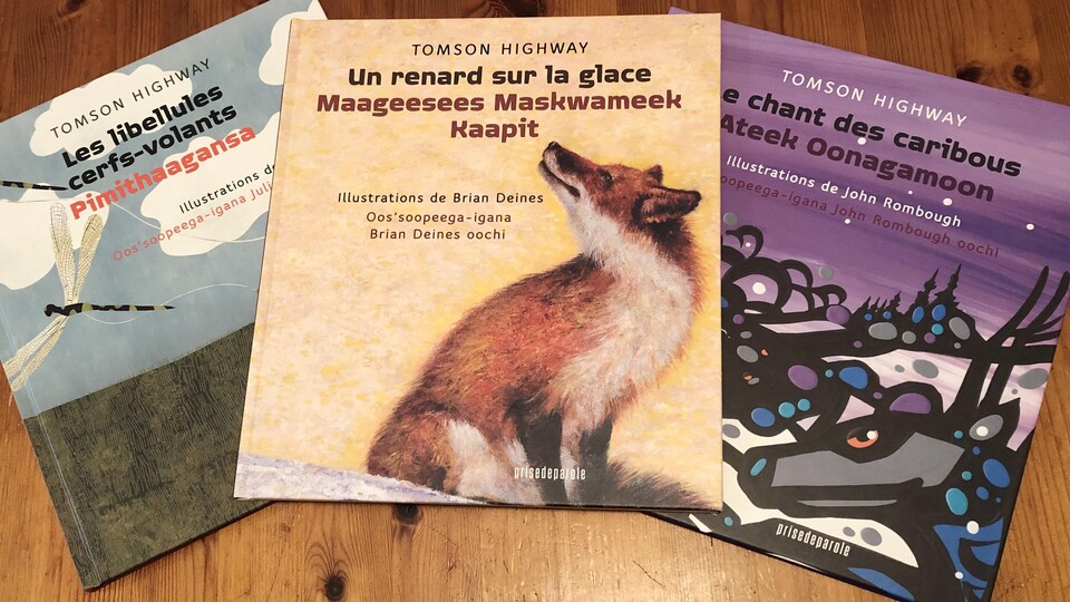 Trois albums jeunesse écrits par l'auteur cri Tomson Highway dispersés sur une table.
