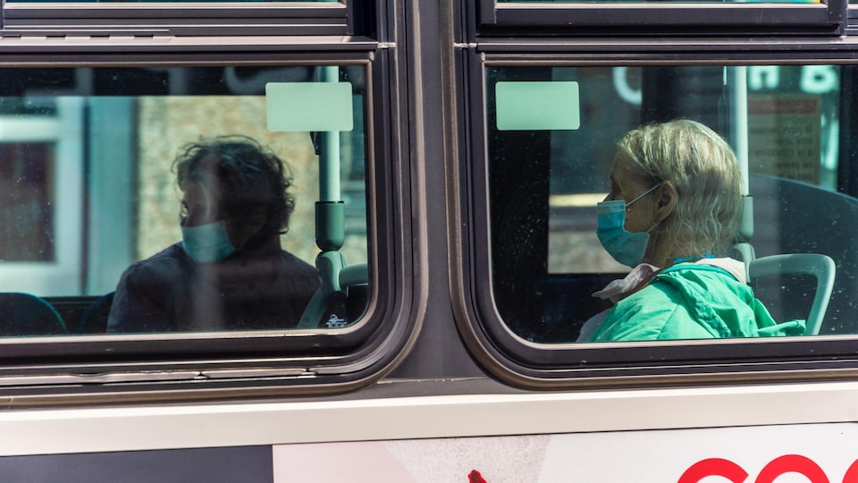 Des personnes sont assises dans un autobus de Montréal.