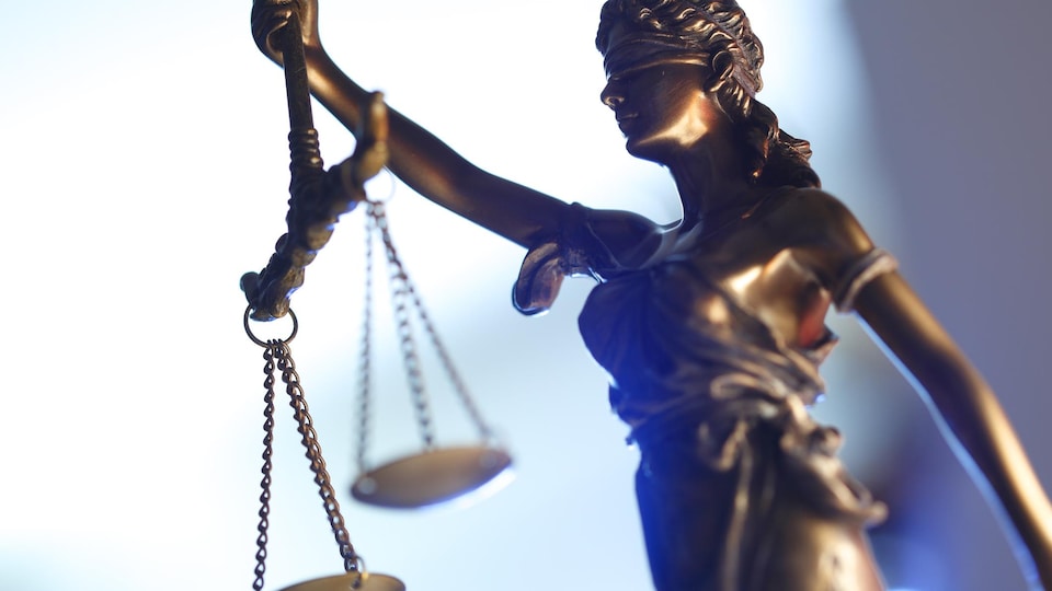 Une photo est prise d'une statue d'une balance, symbole de la justice.