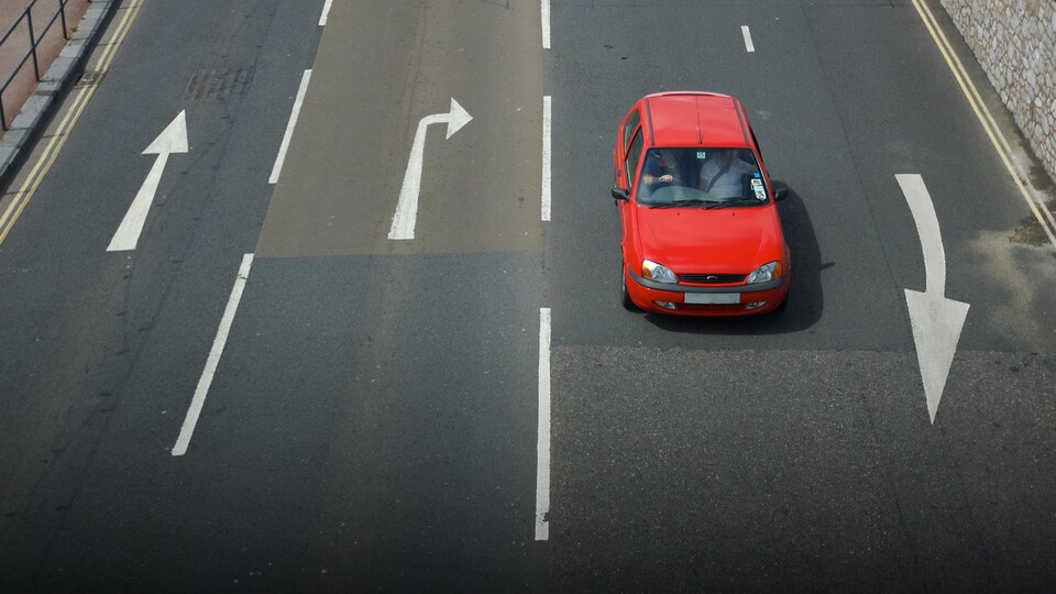 Une personne conduit à gauche sur une route du Royaume-Uni.