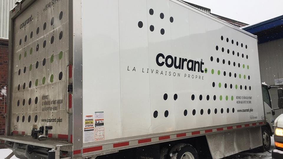Un des camions électriques de Courant Plus est garé dans le stationnement de l'entreprise.