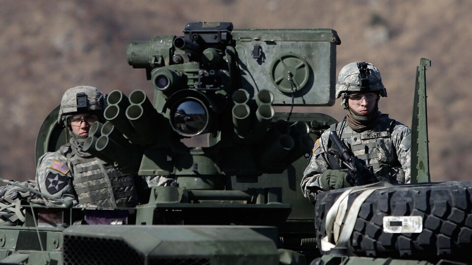 Deux soldats américains à bord d'un tank lors d'un exercice militaire.