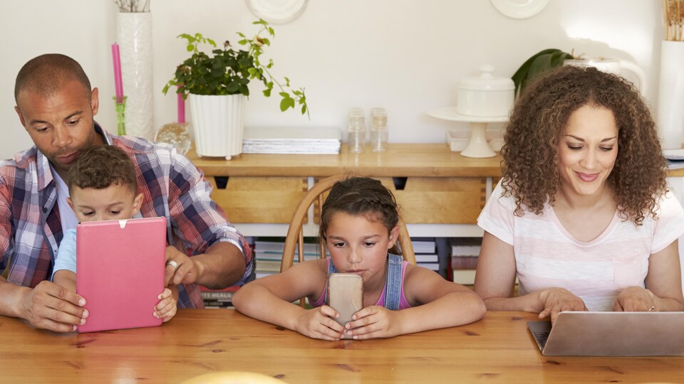 Les membres d'une famille utilisent Internet sur différents supports.