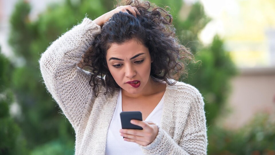 Une femme se pose des questions après avoir reçu un courriel.