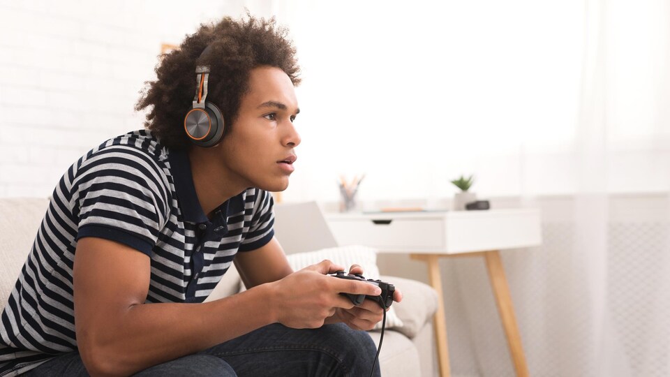 Une personne très concentrée joue à un jeu vidéo.