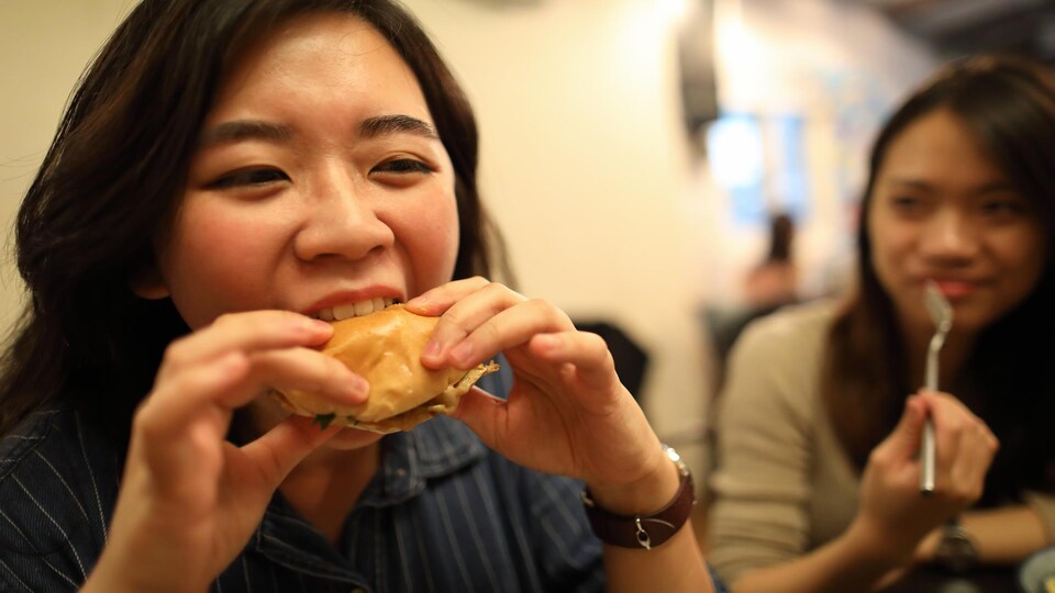 Une personne mange avec appétit de la nourriture dans un restaurant.