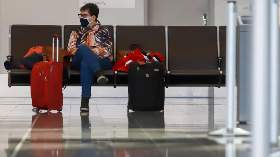 Un passager assis à l'aéroport international de Calgary, en pleine pandémie mondiale de la COVID-19.