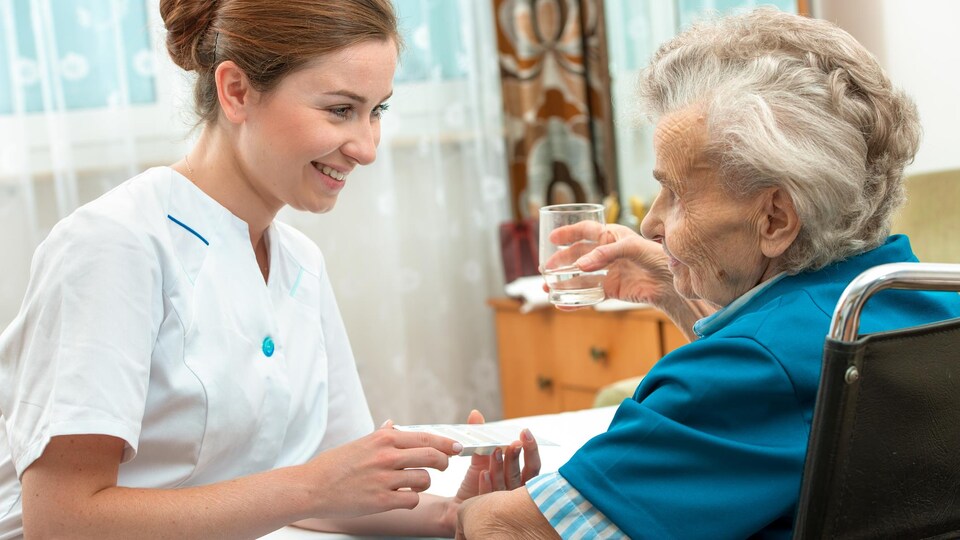 Une femme prodigue des soins à une patiente.