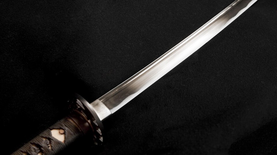 Un sabre japonais brille à la lumière.