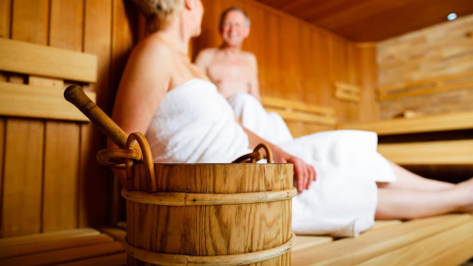 Deux personnes profitent d'un moment de détente dans un sauna finlandais.