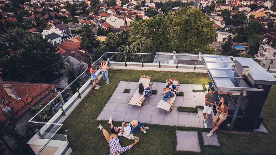 Des personnes passent du bon temps sur la terrasse d'un édifice à condominiums.