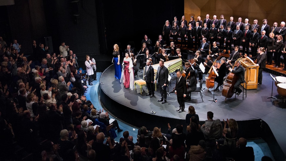 Le public ovationne les solistes, les musiciens et le choeur sur la scène.