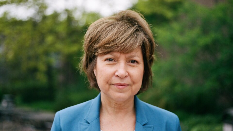 Elle sourit à la caméra.