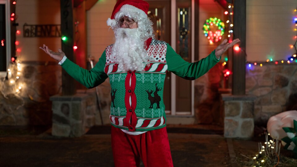 Michel Bénac is disguised as Santa Claus with a green sweater.