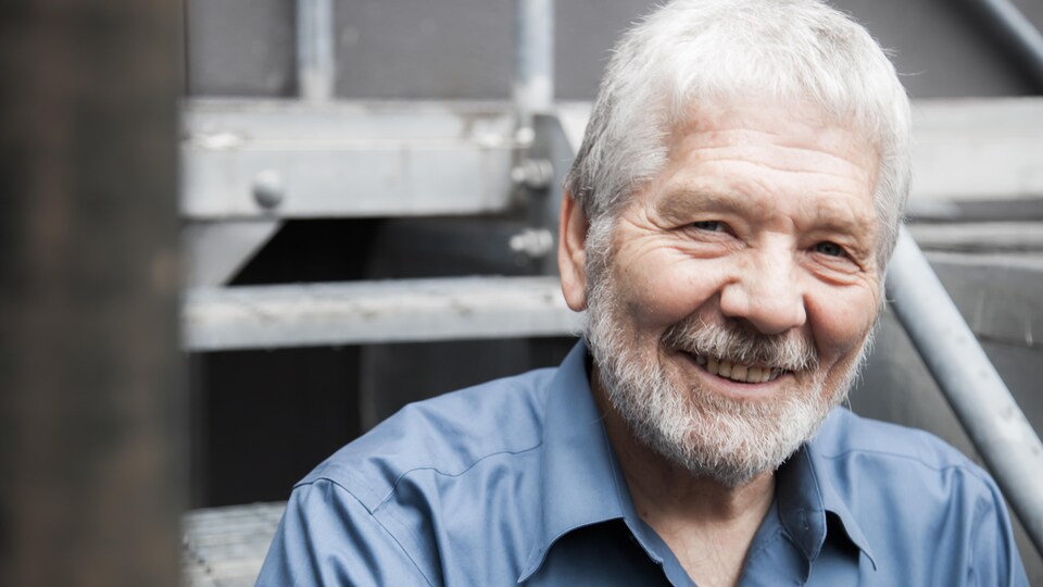 Un homme souriant à la caméra.