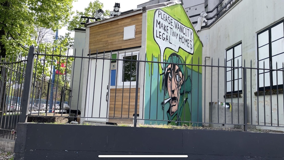 Une mini-maison avec une murale dessinée sur un des murs.