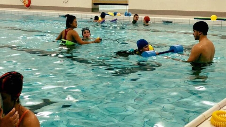 Des jeunes vivant avec des limitations fonctionnelles dans une piscine du YWCA et leurs moniteurs.