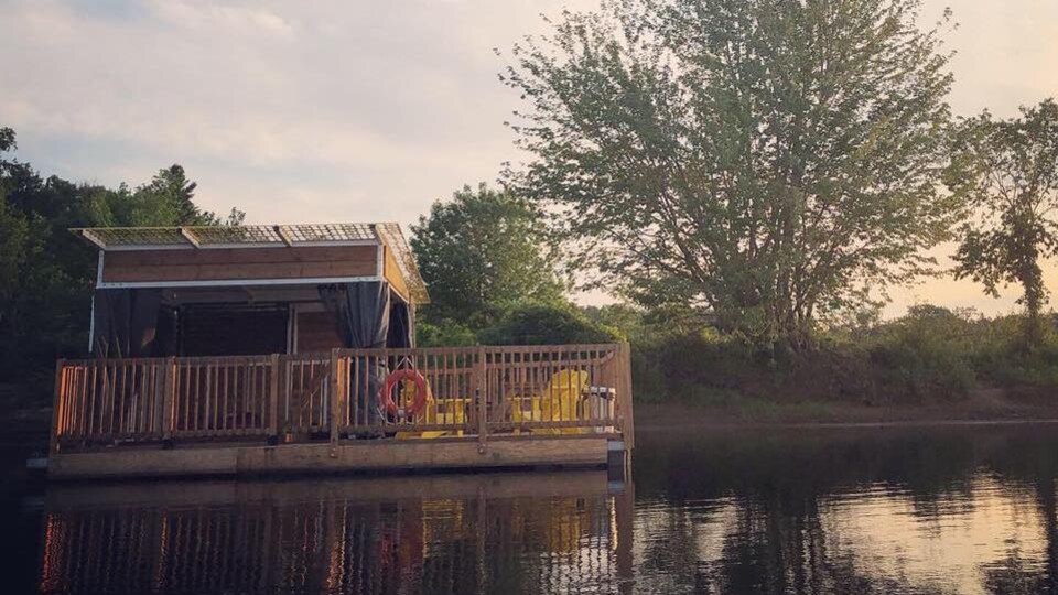 En forêt, sur le bord d’un lac calme, un petit chalet flottant dans lequel Mireille a passé la nuit